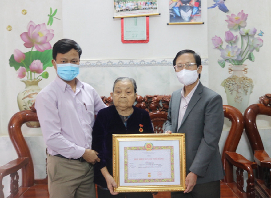 Phó Bí thư Thường trực Huyện ủy Bình Sơn trao huy hiệu 55 năm tuổi đảng cho đảng viên Võ Thị Lai